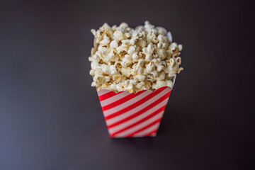 Popcorn in red and white container on a dark background