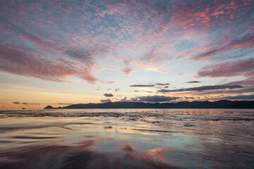 Fototapeta na wymiar Sunset sky reflecting on the surface of the sea water
