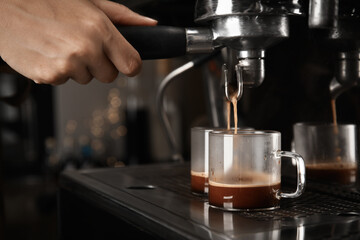 Barista making espresso using professional coffee machine, closeup