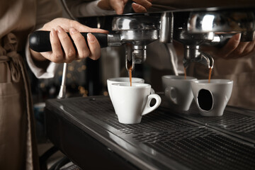 Barista making espresso using professional coffee machine, closeup