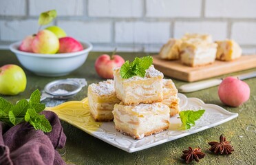 Sliced apple pie made from shortcrust pastry with cottage cheese cream and apple wedges on a square...