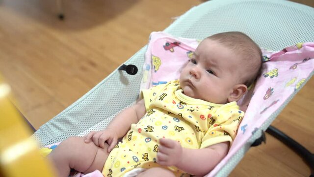 Newborn baby swinging in a baby rocking chair