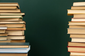 Many hardcover books near green chalkboard, space for text. Library material