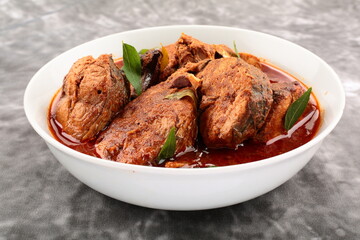 Homemade spicy Kerala fish curry cooked in gravy .