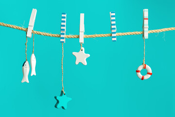 Nautical concept with sea lifestyle decorations hanging on rope with turquoise. Sea toys lifeline, seastars and small fish