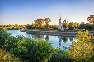 Obraz premium Sretenskaya church on the river bank and reflection in the river in Vologda on an early summer morning