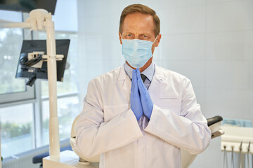 Fototapeta premium Expressive dentist making pleading gesture with his hands