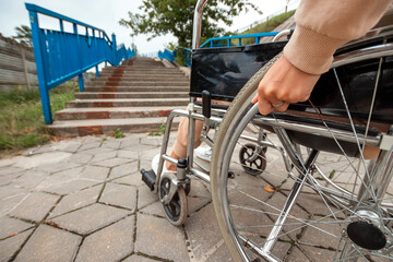 Obraz premium Close-up of legs in a wheelchair. The girl is disabled. The concept of a wheelchair, disabled person, full life, paralyzed, disabled person, health care.