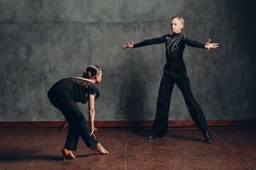 Couple dancers in black costumes dancing in ballroom rumba dance