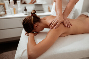 Obraz na płótnie Canvas Female client receiving therapeutic massage in spa salon