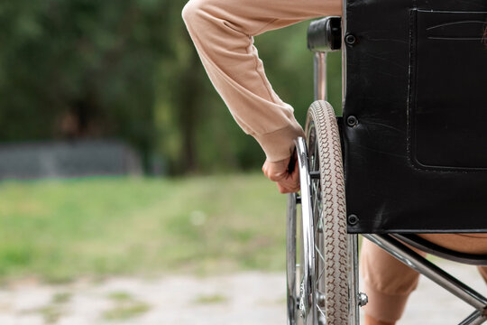 Close-up of a hand on a wheelchair wheel. The concept of a wheelchair, disabled person, full life, paralyzed, disabled person, happy life.