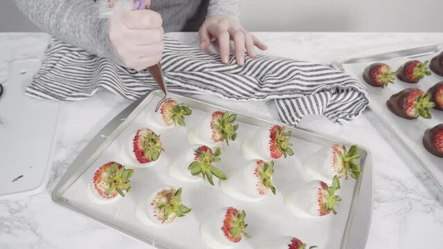 Time lapse. Step by step. Drizzling melted chocolate from pastry piping bag to chocolate covered strawberries.