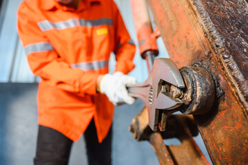 Close-up photo of tractor mechanic Hold a large spanner or an adjustable wrench. used for large vehicles Auto parts and tools, wrenches and heavy-duty equipment in the garage.
