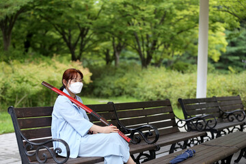 Korean woman practicing kendo in a hi-dong kendo pose with a sword.