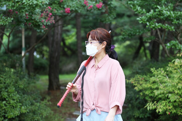 Korean woman practicing kendo in a hi-dong kendo pose with a sword.