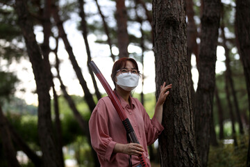 Korean woman practicing kendo in a hi-dong kendo pose with a sword.