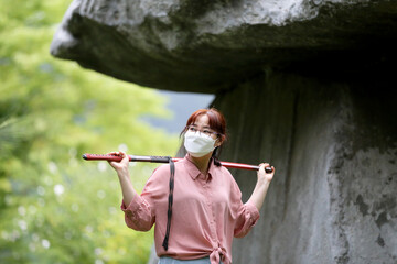 Korean woman practicing kendo in a hi-dong kendo pose with a sword.