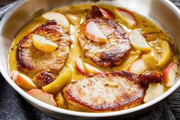 pork chops in apple cider cream sauce in a pan