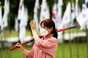 Korean woman practicing kendo in a hi-dong kendo pose with a sword