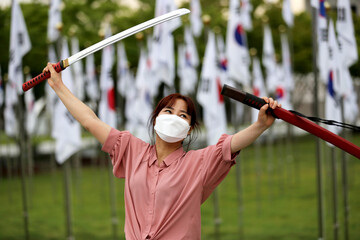 Korean woman practicing kendo in a hi-dong kendo pose with a sword