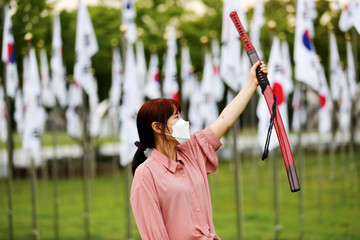 Korean woman practicing kendo in a hi-dong kendo pose with a sword