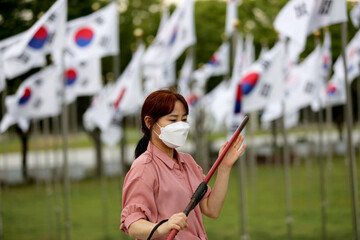 Korean woman practicing kendo in a hi-dong kendo pose with a sword