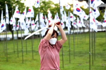 Korean woman practicing kendo in a hi-dong kendo pose with a sword