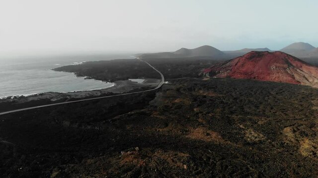 vulcanic valley with mountains in the background on a sunny day in Lanzarote Aerial Drone Footage