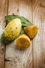 prickly pears and leaves over wooden background