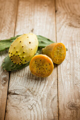 prickly pears and leaves over wooden background