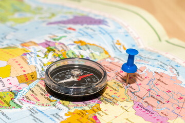 a compass lying on a geographical map buttons mark the place of travel the concept of a tourist