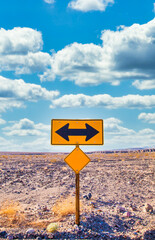 Directional sign in the desert with scenic blue sky and wide horizon. Concept for trip, freedom and transportation.