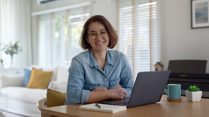 Asia smart people or latin sme owner sit on desk table at home look at camera enjoy read e-mail on...