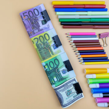 Financial, creativity and art background still life with euro and dollar banknotes in assorted denominations and colorful arrangements of marker pens and pencil crayons