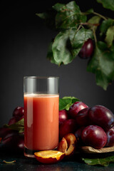Plum juice and fresh purple plums.