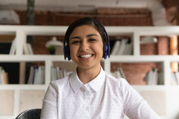 Web cam head shot Indian woman applicant pass job interview remotely by video call. Student participates in educational webinar seated alone in library. Virtual event meeting profile picture concept