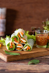 Fototapeta na wymiar Closed up fresh Asian spring rolls as portion stuff vegetable, pork inside noodle tubes with spicy sauce, healthy food
