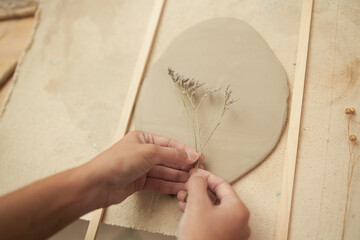 Artisan making botanical print on clay