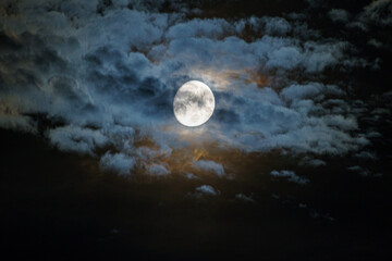 Fototapeta na wymiar La Lune derrière un ciel nuageux coloré