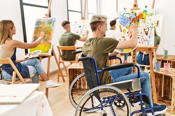 Group of people drawing at art studio. Young man sitting on wheelchair.