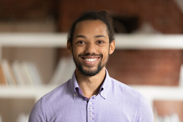 Optimistic African male employee head shot in modern office. Portrait of successful skilled...