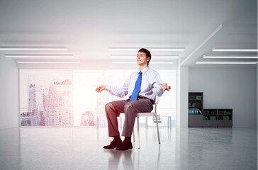 young businessman meditating in the office