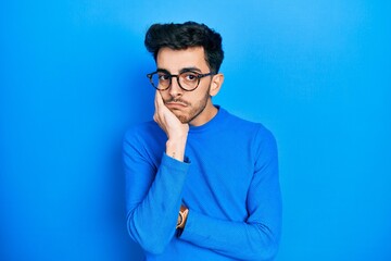 Young hispanic man wearing casual clothes and glasses thinking looking tired and bored with depression problems with crossed arms.