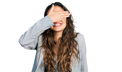 Young hispanic girl wearing business clothes and glasses smiling and laughing with hand on face covering eyes for surprise. blind concept.