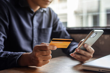 Businessman use credit card to shopping online in internet website shop with smart phone on work table in office.
