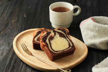 Loaf Marble Cake Slice on Black Wooden Background, Served with Tea