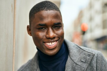 Fototapeta premium Young african american man smiling happy standing at the city