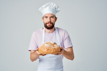 a man in a white apron with bread in his hands baking and cooking