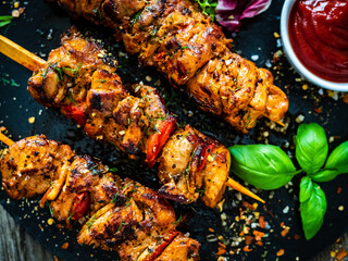 Skewers - grilled meat with fresh vegetables on wooden background

