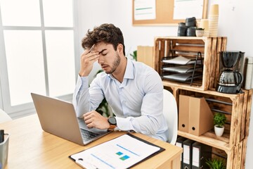 Naklejka premium Young hispanic businessman overworked working at the office.
